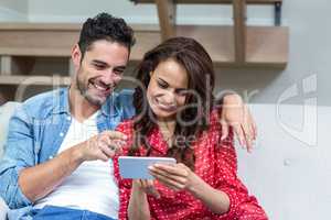 Smiling couple using smartphone