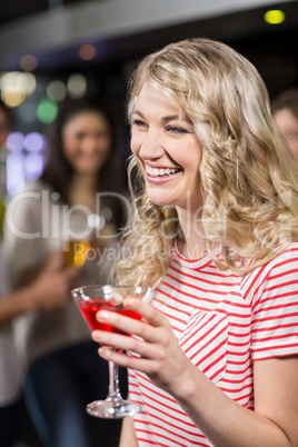 Blonde woman having cocktail with her friends