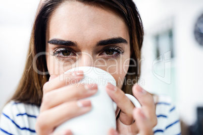 Portrait of young woman drinking coffee