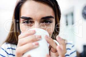 Portrait of young woman drinking coffee