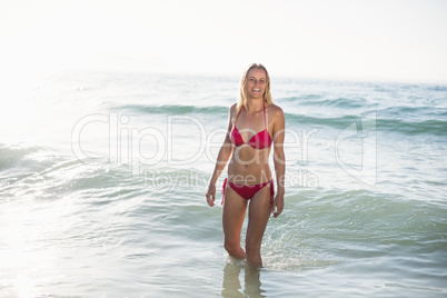 Young woman in bikini standing in water