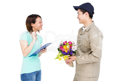Delivery man taking signature of woman while delivering flowers