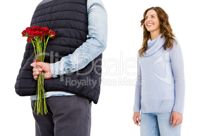 Man hiding a rose behind his back from his woman