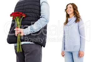 Man hiding a rose behind his back from his woman