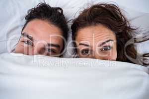 Close-up portrait of couple relaxing on bed