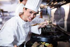 Chef smelling fried fish in the kitchen
