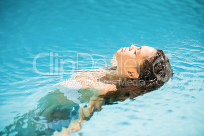 Beautiful woman floating in pool