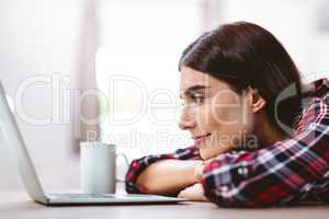 Happy young woman looking at laptop
