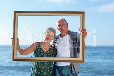 Senior couple posing with a frame