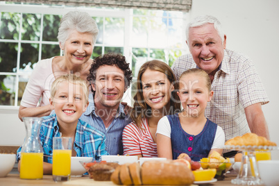 Happy multi-generation family by breakfast table