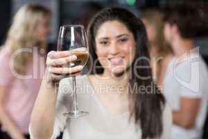 Smiling girl having a glass of wine with her friends