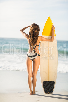 Woman holding surfboard at the beach