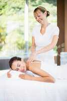 Female masseur massaging woman at spa