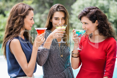 Young female friends drinking cocktail