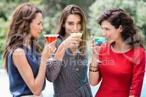 Young female friends drinking cocktail