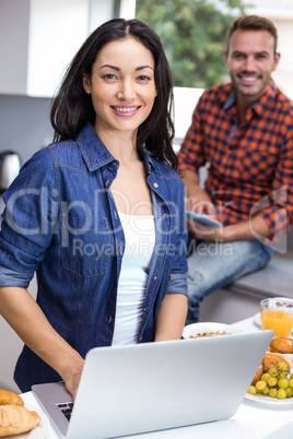 Young woman using laptop and man using digital tablet