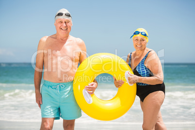 Senior couple with swimming ring at the beach