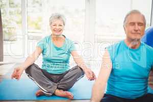 Portrait of smiling senior woman with husband meditating