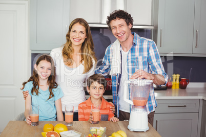 Portrait of smiling parents and children with fruit juice