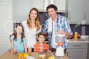 Portrait of smiling parents and children with fruit juice