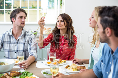 Smiling woman holding white wine glass with friends