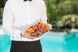 Midsection of waiter holding food tray