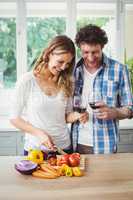 Smiling couple holding wineglasses in kitchen
