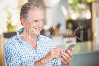 Happy senior man using mobile phone