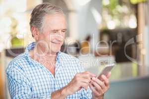 Happy senior man using mobile phone