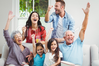 Multi generation family on cheering sofa