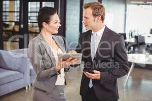 Businessman and businesswoman using digital tablet