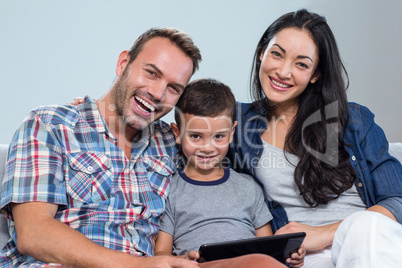 Mother, father and son using digital tablet