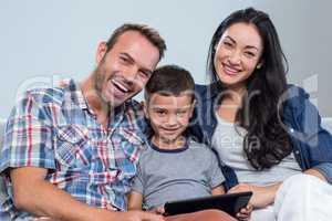 Mother, father and son using digital tablet