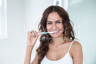 Young woman brushing teeth in bathroom