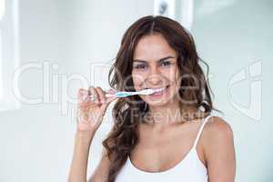 Young woman brushing teeth in bathroom