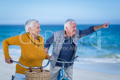 Senior couple with bikes pointing