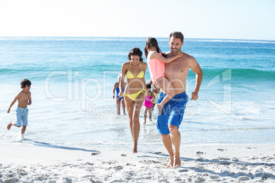 Happy family walking on the beach