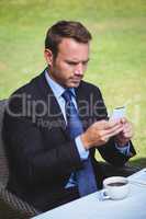 Focused businessman looking at his smartphone