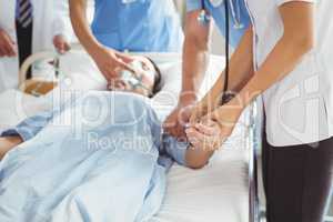 Doctor checking female patient pulse