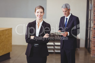 Businesswoman with male colleague standing in background
