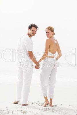 Portrait of happy couple standing on the beach