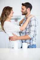 Couple embracing by table at home