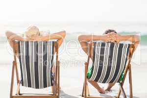 Rear view of couple relaxing on the beach