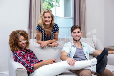 Happy multi-ethnic friends relaxing at sofa