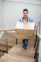 Portrait of handsome man holding cardboard box