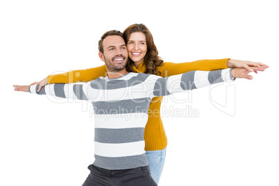 Young couple standing with arms outstretched