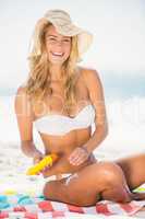 Smiling woman applying sunscreen