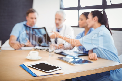 Digital tablet and file on table in conference room
