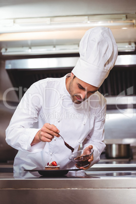 Chef putting chocolate sauce on a dessert