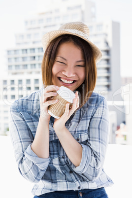 Young woman holding disposable cup